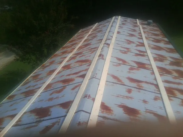 Rusted metal roof panels with new wood purlins before replacement — Storm Damage Roof Repair in Weogufka by Roofing Brothers